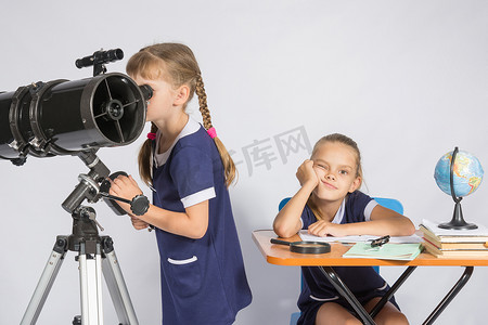 学生望远镜摄影照片_一个女孩透过望远镜看，另一个女孩在等待悲伤的结果