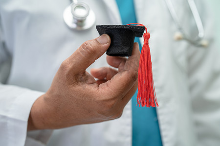 医学学习摄影照片_亚洲医生在医院病房学习毕业差距帽，聪明聪明的天才教育医学理念。