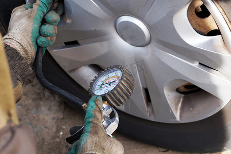 汽车修理工检查车轮的压力