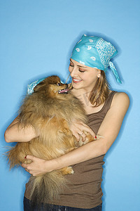 少女抱着波美拉尼亚狗。