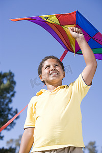 带着风筝在户外微笑的小男孩