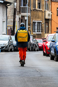 2022 年在罗马尼亚布加勒斯特骑自行车的 Glovo 送餐员