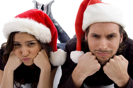 圣诞帽服装摄影照片_近距离观看年轻夫妇戴着圣诞帽，看着