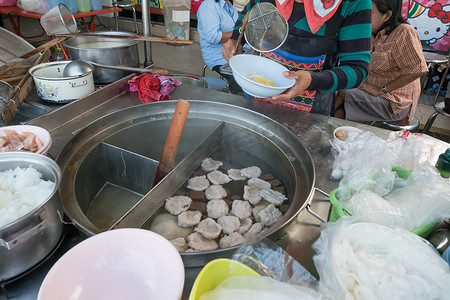跳蚤市场幼儿园摄影照片_妇女在传统水上市场的船上卖面条