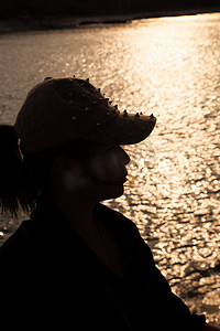 一个戴着帽子的女人的背光剪影。