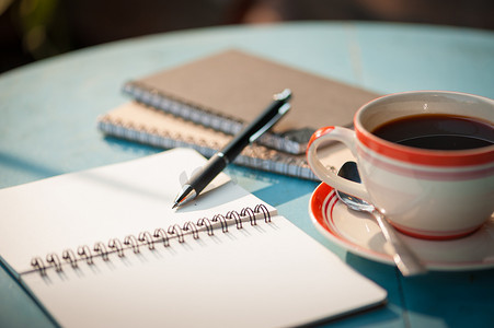 木桌上的笔记本和咖啡杯