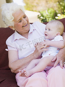 祖母在户外露台上带着婴儿微笑