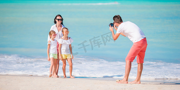 一家四口定制摄影照片_四口之家在海滩度假时自拍的全景图。