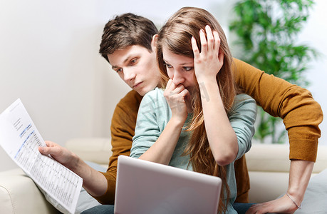 年轻焦虑的夫妇咨询他们的银行账户