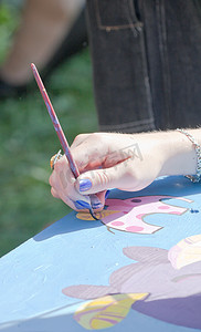 手用画笔描绘了一幅色彩缤纷的图画