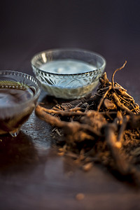 生阿育吠陀草药 chitrak/Plumbago zeylanica 根在棕色光亮的表面上，带有一些酪乳、酥油或澄清黄油、其提取物、凝乳和蜂蜜，用于阿育吠陀疗法。