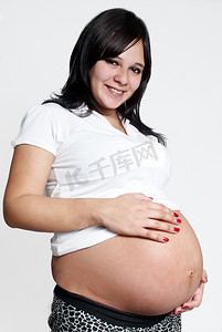 胖孕妇摄影照片_孕妇在浅色背景上的肖像