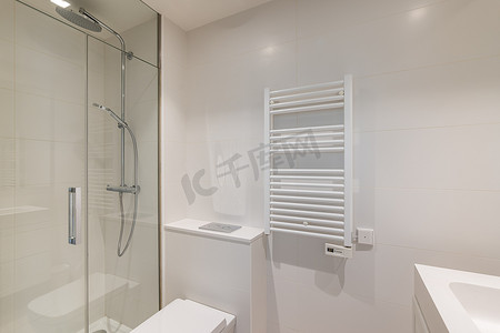 浴室采用浅色设计，配有光滑的瓷砖墙壁和明亮的灯光。