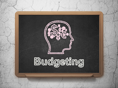 财务概念： 头与财务符号和预算在黑板背景