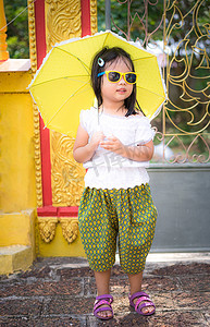 儿童服饰样机摄影照片_戴墨镜的泰式服饰中快乐的亚洲小女孩和