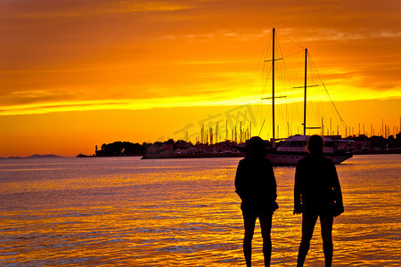 欧洲人物摄影照片_海上金色夕阳下的人物剪影
