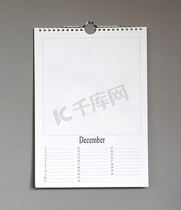 挂机摄影照片_挂在灰色墙上的简单旧生日日历 — 12 月
