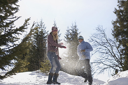 一对夫妇在山上玩雪的低视角