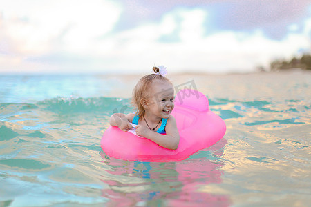 在海中充气气垫上放松的小女孩