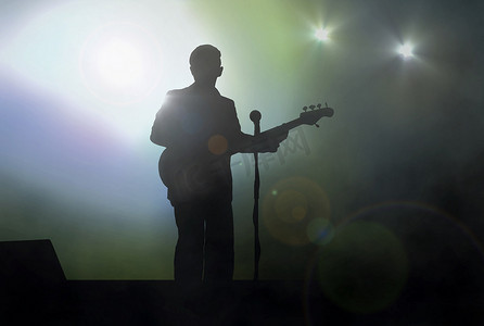 舞台上的吉他手在聚光灯下现场表演