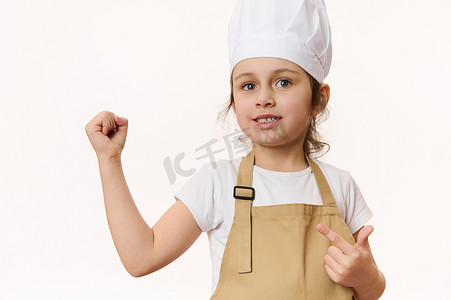 漂亮的小女孩 — 身着围裙和帽子的厨师糕点在白色背景中突显，并有免费空间供宣传文字