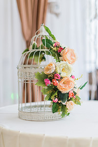 婚礼上用鲜花装饰的白色笼子