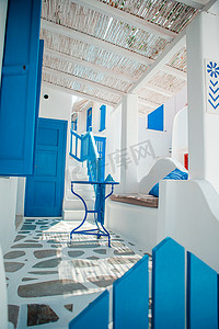 希腊岛上狭窄的街道上有蓝色的阳台、楼梯和鲜花。