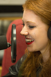 漂亮的红头发学生正在主持广播节目