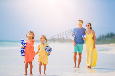爸爸女儿照片摄影照片_幸福的家庭在海滩上玩耍的照片。