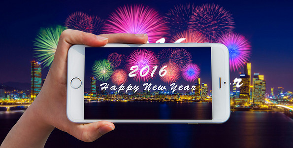 手拿着智能手机拍照在新年快乐 2016 年和