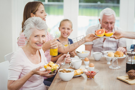 幸福的多代家庭在早餐时吃水果