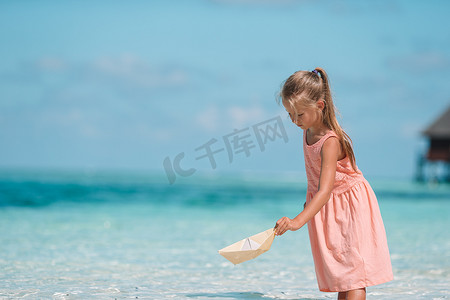 可爱的孩子在海里玩纸船