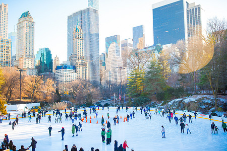 溜冰公园摄影照片_冬天在纽约中央公园玩乐的溜冰者