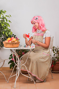 司法假发摄影照片_戴着粉红色假发的年轻女孩创造折纸