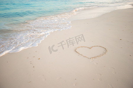 在热带海滩上用白色沙子画的心