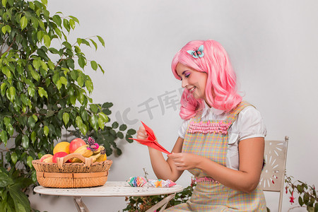 男神折纸剪影摄影照片_戴着粉红色假发的年轻女孩创造折纸