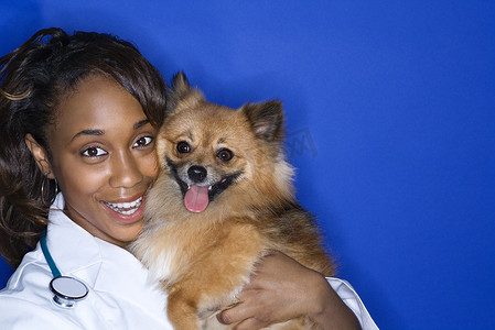 女兽医抱着棕色的狗。