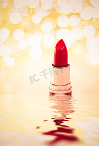 金色背景广告摄影照片_金色背景上的红色唇膏、化妆品和化妆品