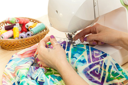机械产品介绍画册摄影照片_女裁缝的手在缝纫机上缝合