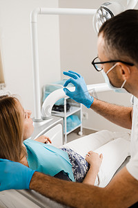 牙医在牙科诊所向女病人展示牙贴面种植牙。