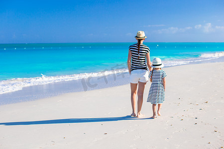 加勒比海滩年轻母亲和小女儿的背影