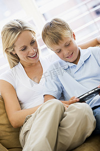 客厅里的女人和小男孩带着手持视频游戏微笑