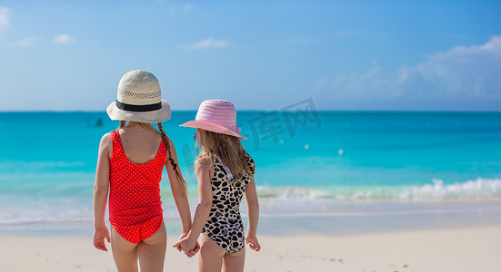 婴儿背影摄影照片_两个小女孩在白色沙滩上看海的背影