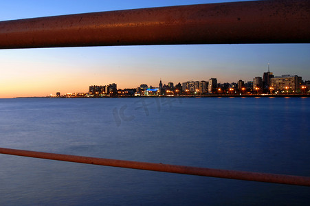 桥梁栏杆后黄昏的城市景观