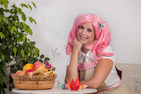 创造生活摄影照片_戴着粉红色假发的年轻女孩创造折纸