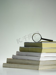 整理文档摄影照片_一堆书和放大镜