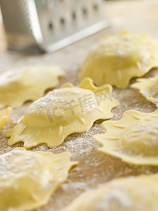 料理机摄影照片_未煮过的菠菜和意大利乳清干酪馄饨在撒了面粉的表面上