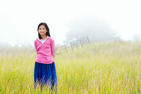 少女静静地站在迷雾笼罩的田野上