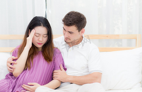 肚子痛摄影照片_怀孕的亚洲妇女肚子痛，感觉不舒服，丈夫有 ta