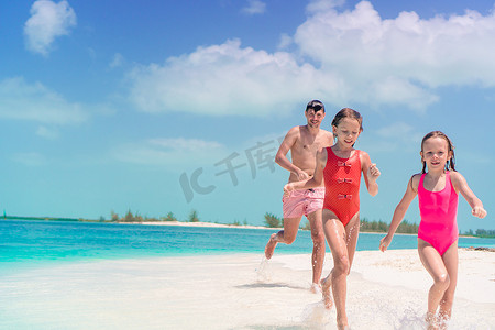爸爸和孩子们在加勒比海岛上的白色热带海滩上散步